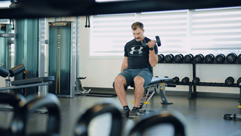a man lifting a dumbbell in a gym